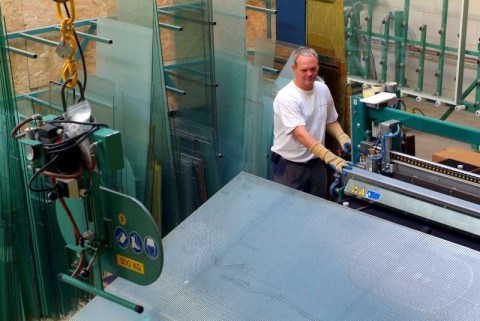Glasmonteur aan het werk in de glashal glas aan het verplaatsen